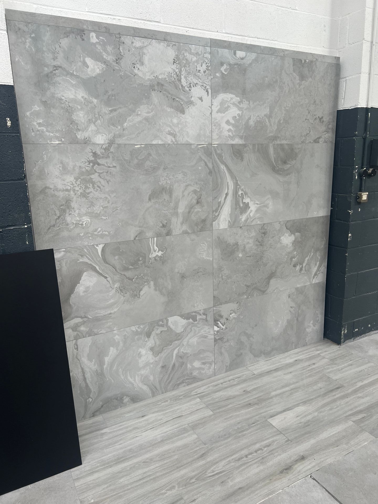 Grey wall tile used in a show room between 2 black metro tiles