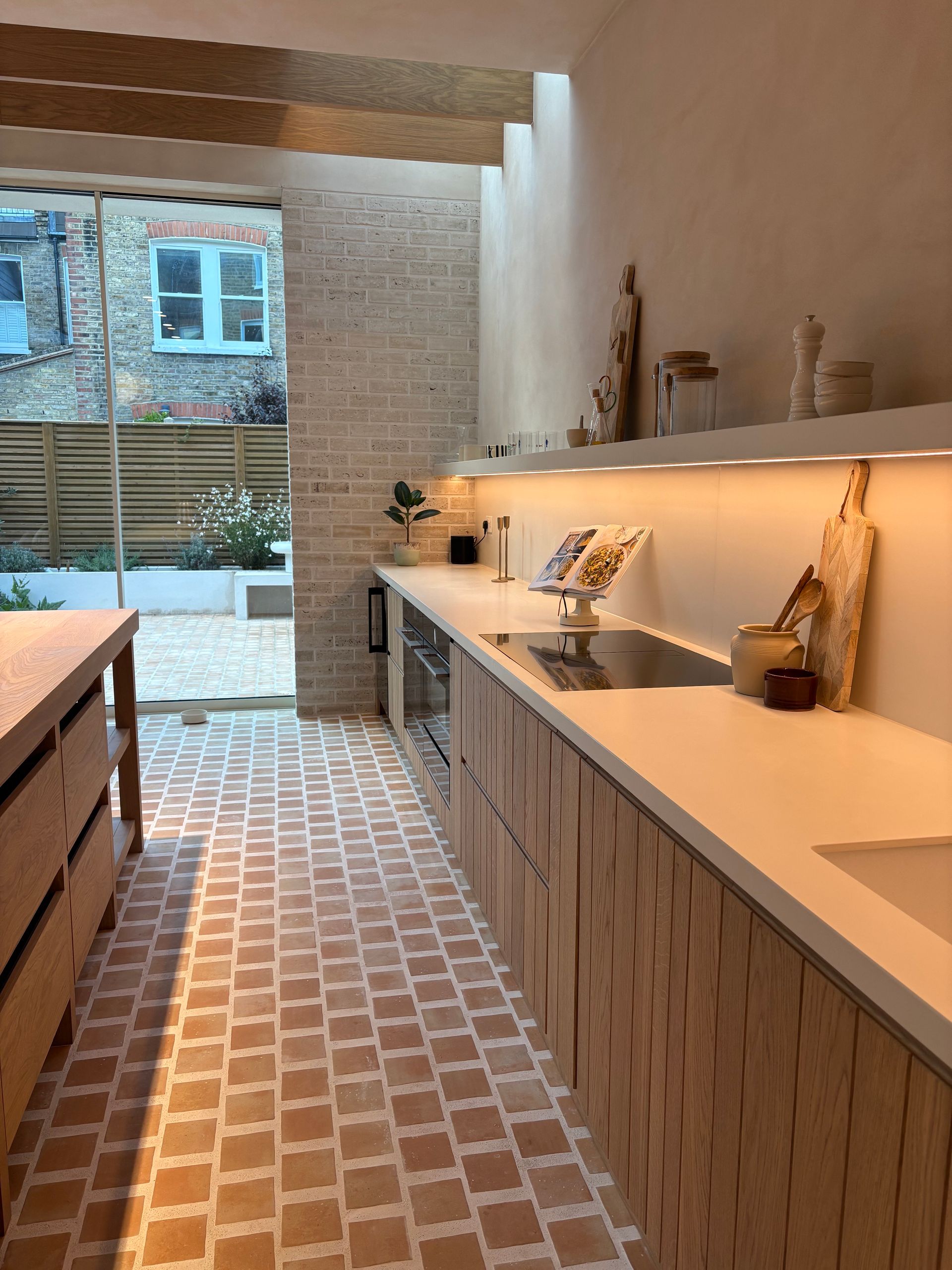 Nativ tile on the floors and walls of this bathroom, black bath and sink with matching black taps