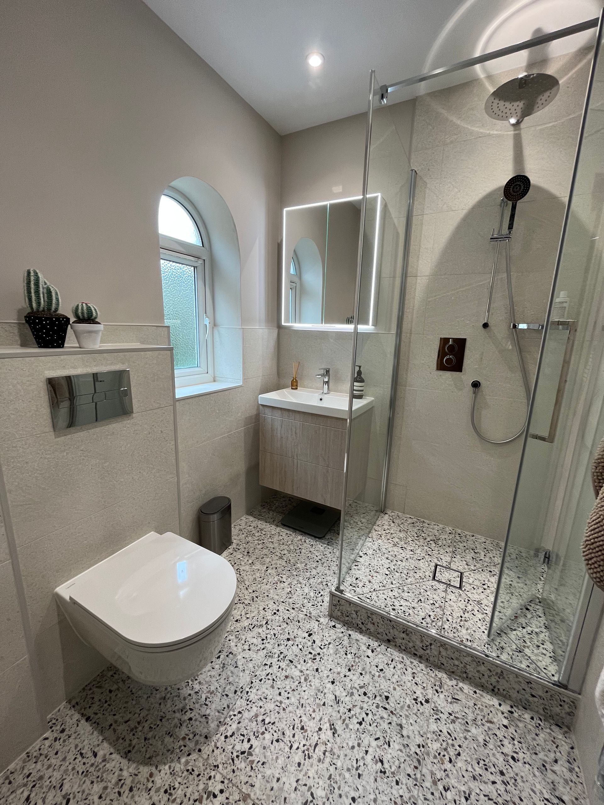 Ceppo Di colour blanco on the floor in a bathroom with chrome shower