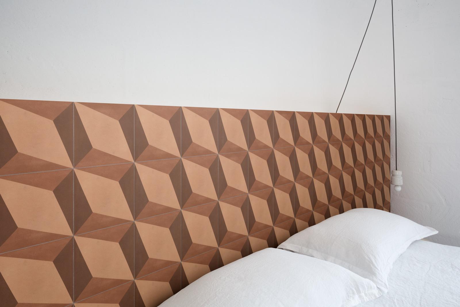 terracotta coloured pattern wall tile as a bed headrest