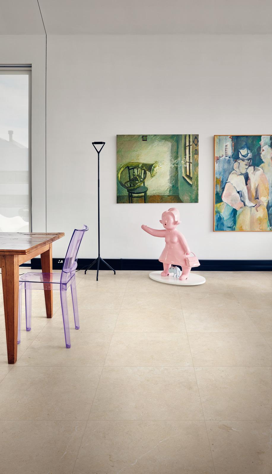 limestone effect tiles , dining room with a wooden table and clear plastic chairs and an abstract painting