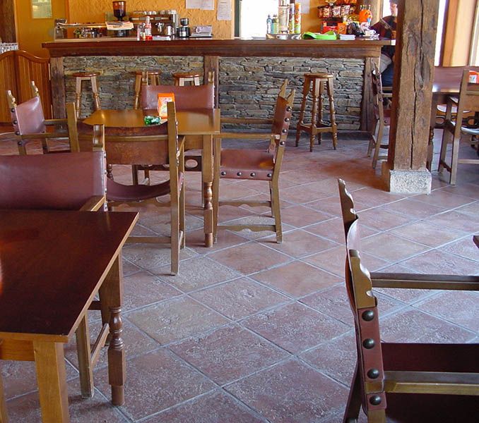 Terracotta floor tiles used in a restaurant with red chairs and tables
