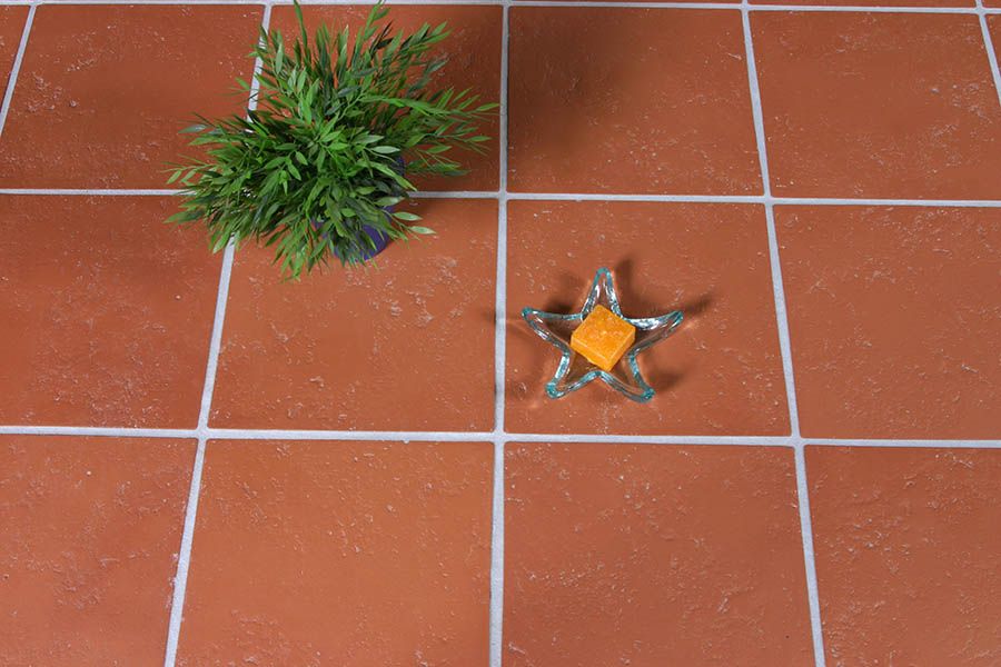 Terracotta floor tiles close up with a star candle and shrubble ontop of them