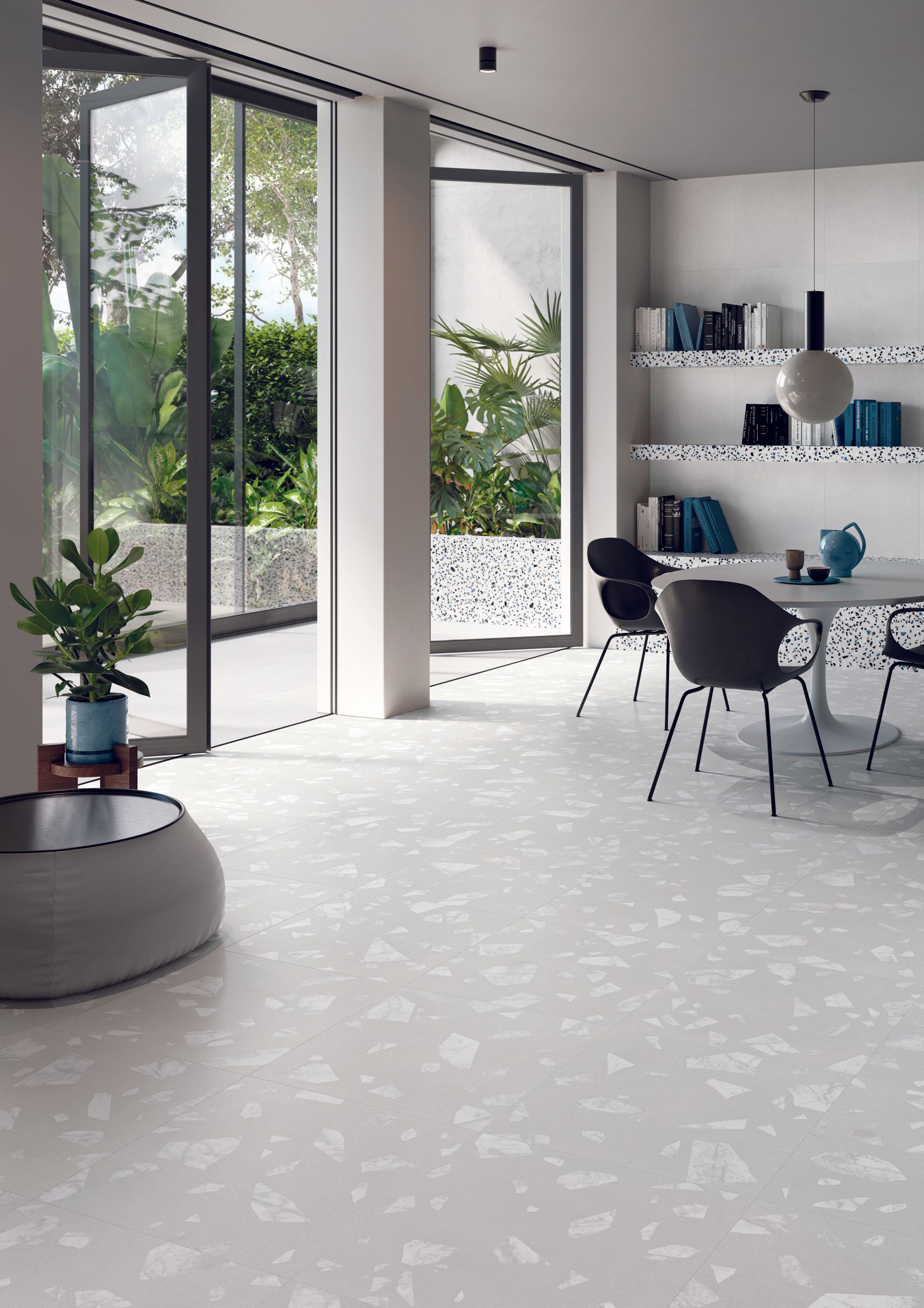 terrazzo tiles , dining room design with black  plastic chairs and a blue feature jug