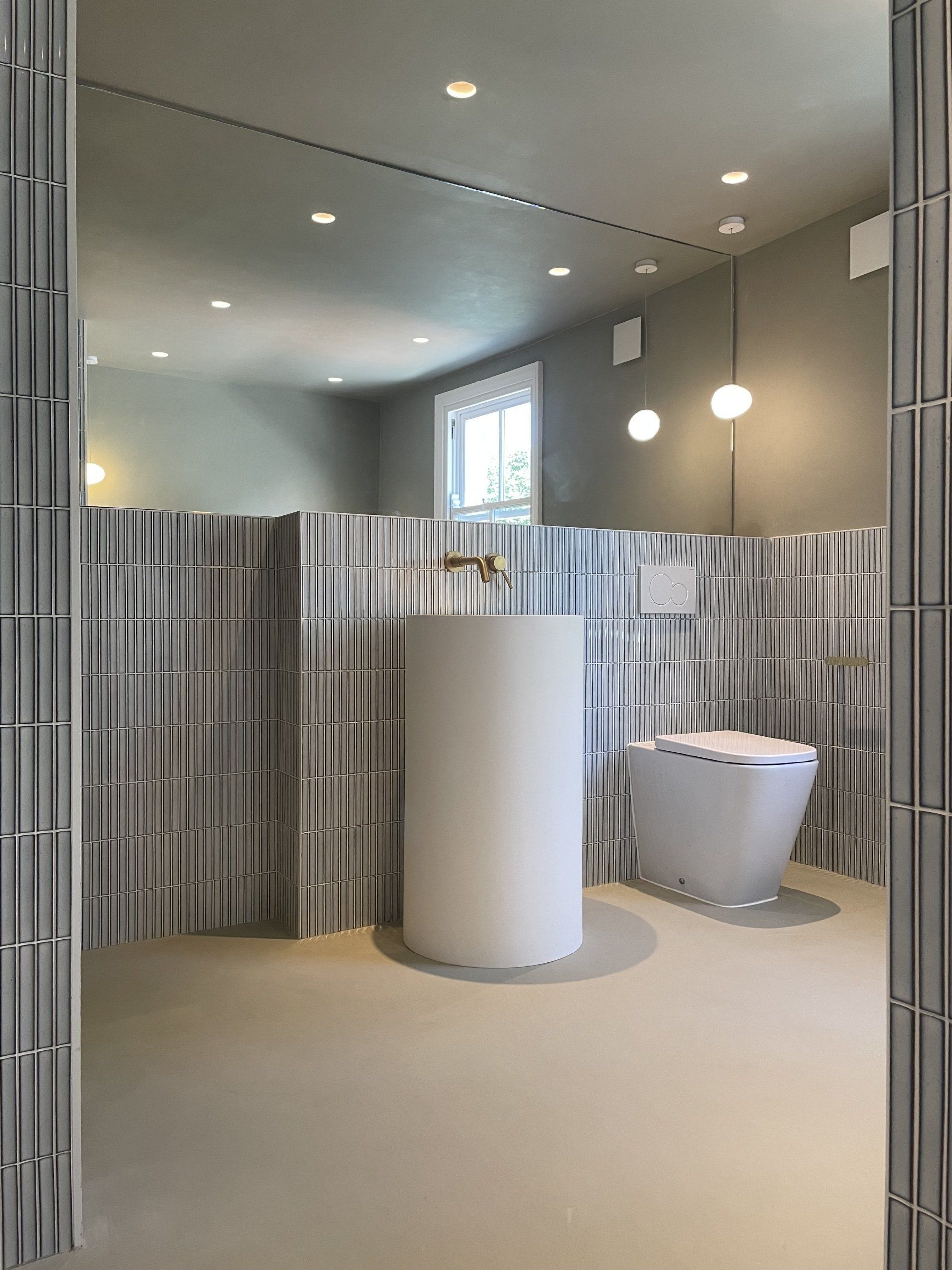 Kit Kat Gris half height tiled bathroom, freestanding white  basin, copper tap, white toilet and white flush plate