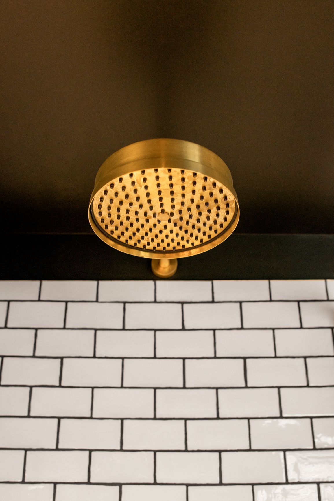 close up of rain flow shower and farmhouse metro tiles