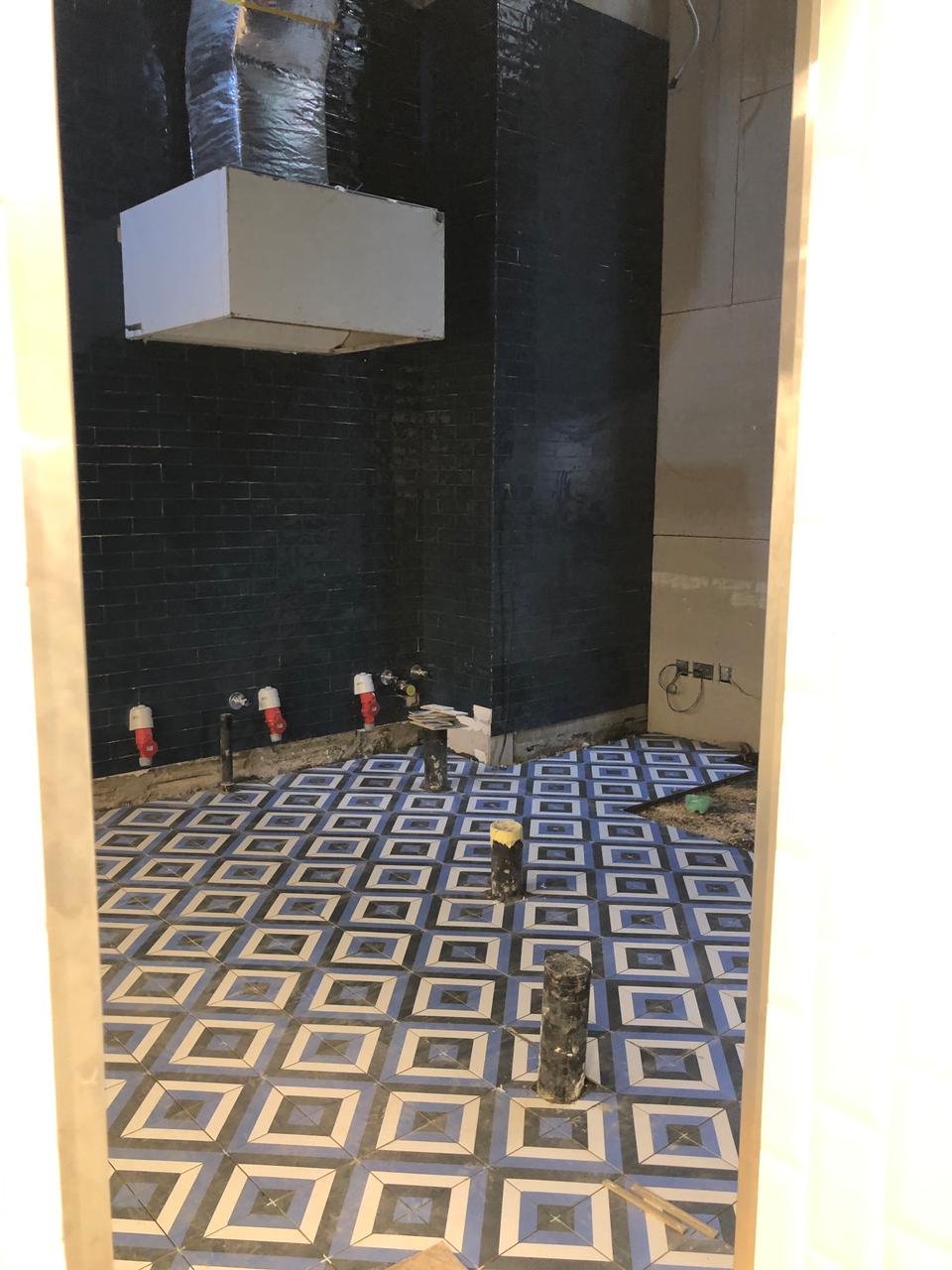 Patterned floor tiles used in contrast to the metro zellige Salerno wall tile