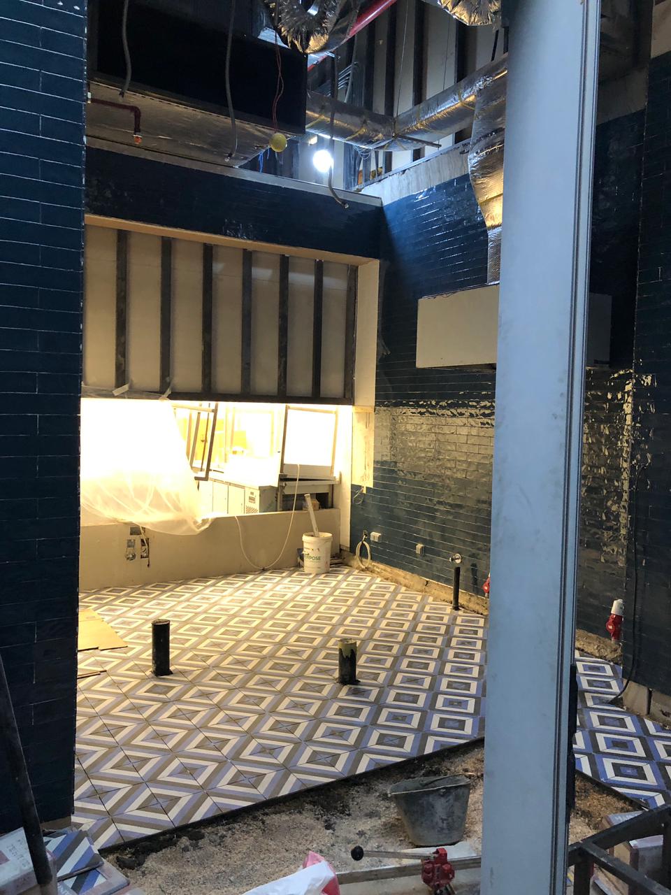 still being built bathroom with blue pattern floor tiles and zellige salerno wall tiles