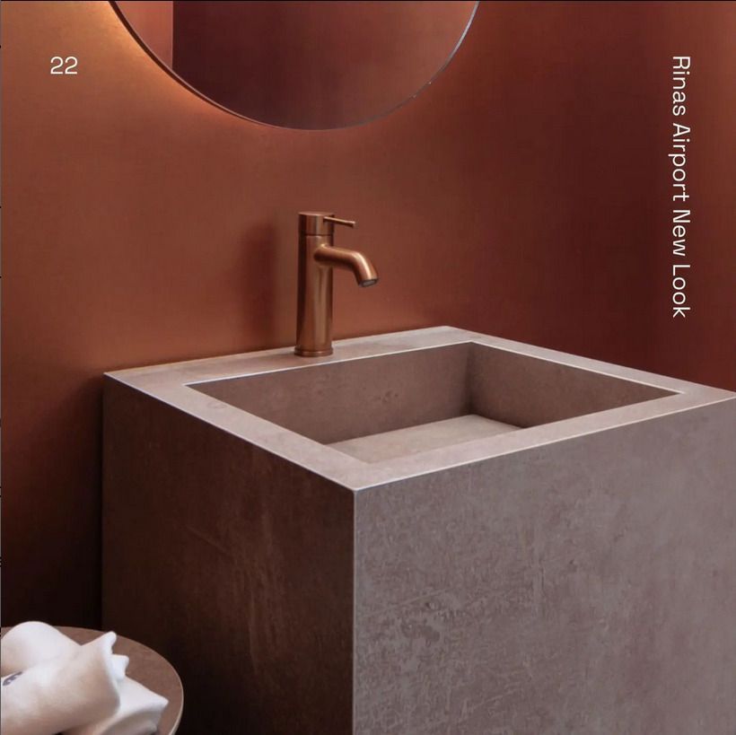 A stylish dining and kitchen space with a marble-topped dining table and dark cabinetry. The wooden wall adds warmth to the modern design, blending with the marble kitchen backsplash.