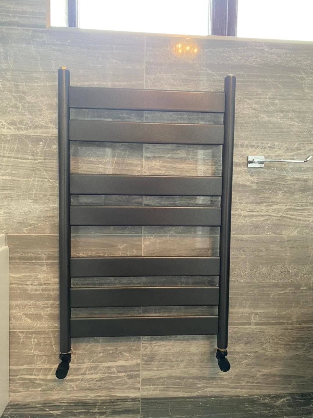 Close up of a towel rail Infront of wall tiles