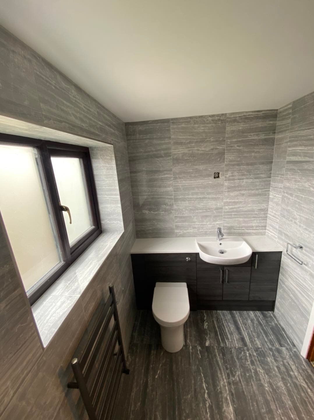 Grey wall tiles used on all walls in the bathroom