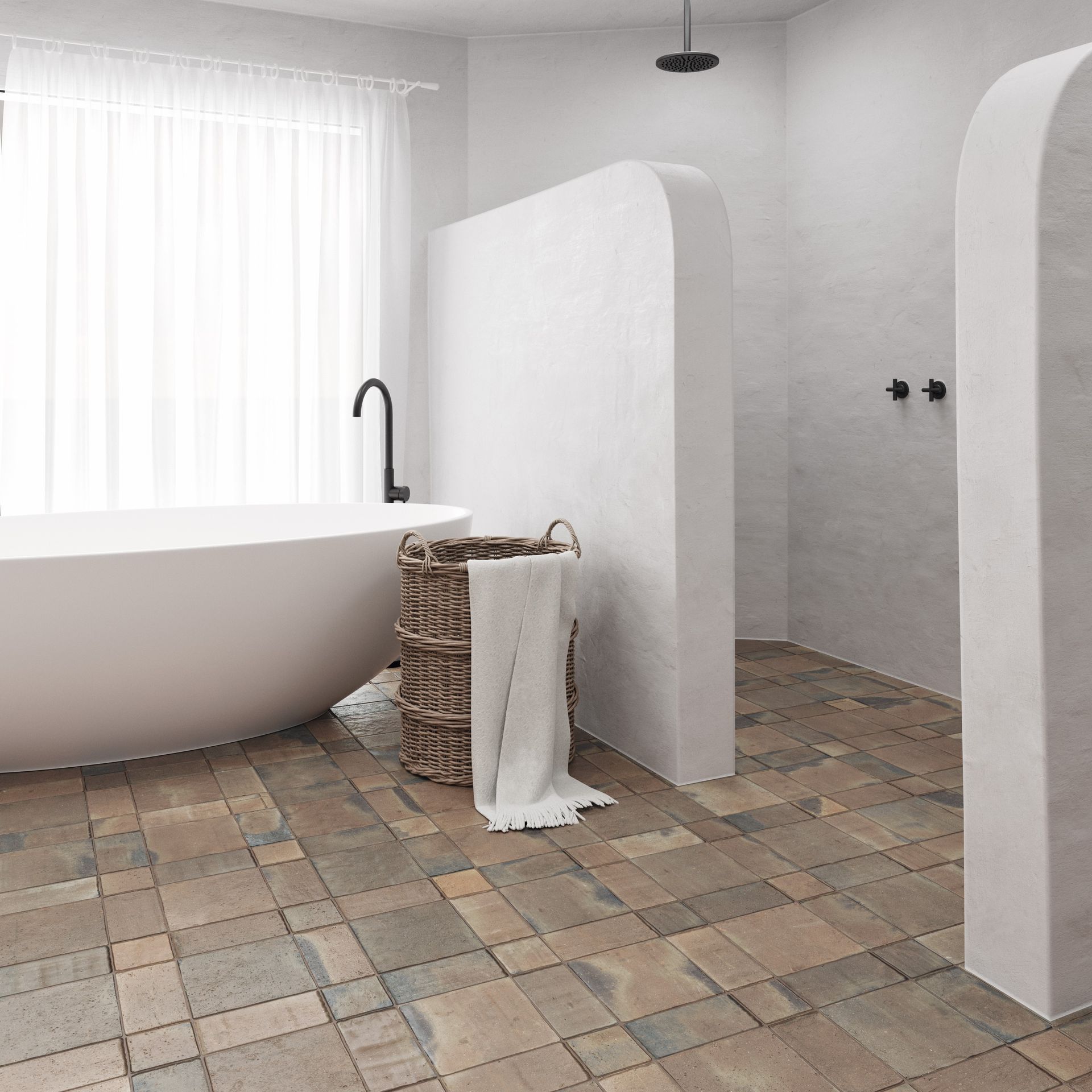 Rustic terracotta tiles used in a bathroom with a white oval bathtub and a black tap