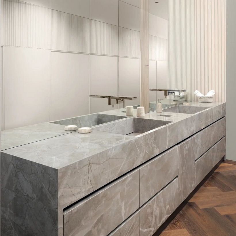 Polished grey marble vanity with twin basins and ample storage, ideal for sleek, modern interiors.