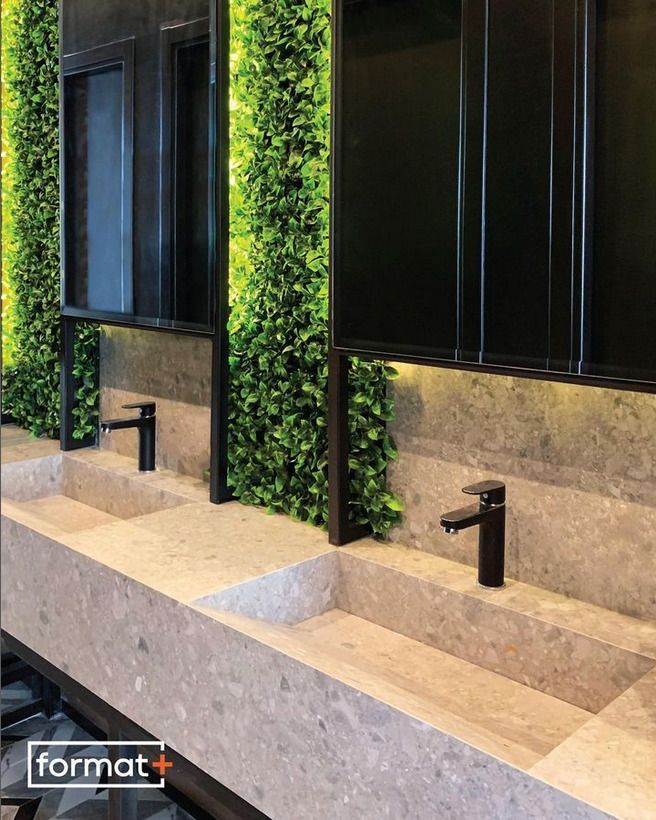 A contemporary double sink vanity with lush green vertical garden panels and matte black faucets, giving a natural and modern feel to the bathroom.