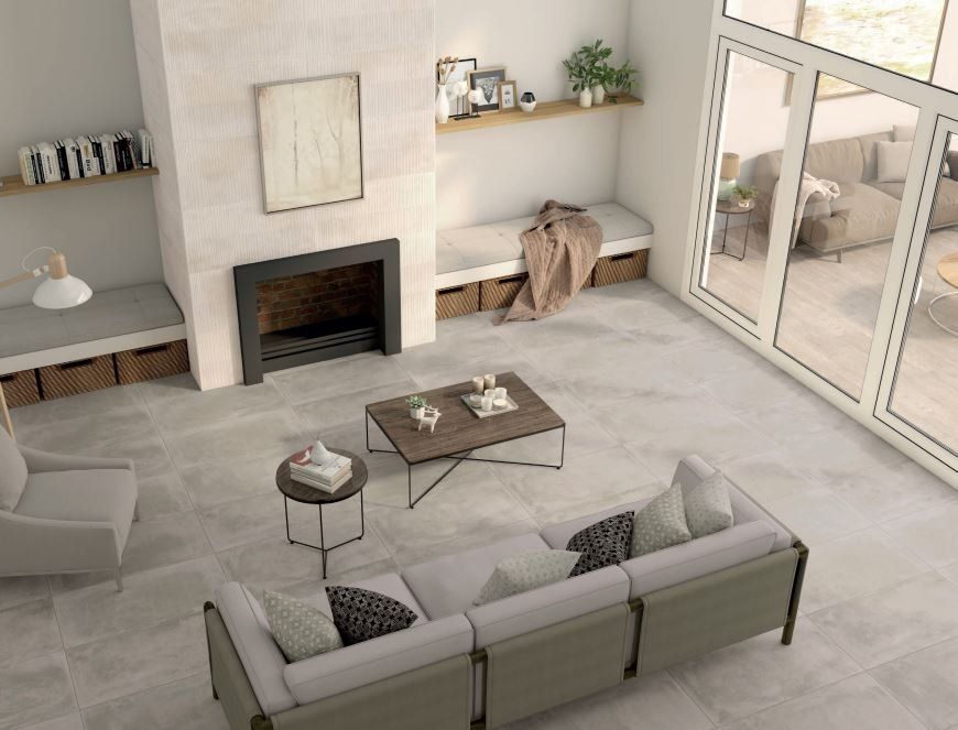 Concrete Floor Tiles in a living room , grey couch facing the tv above a fire place