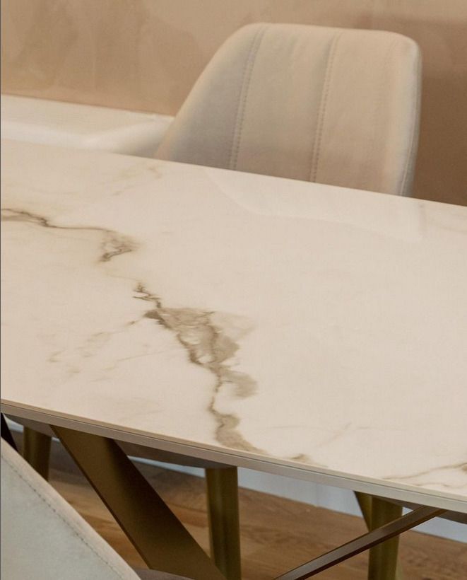 Close-up of a polished white marble table with subtle veining, set in a dining room.