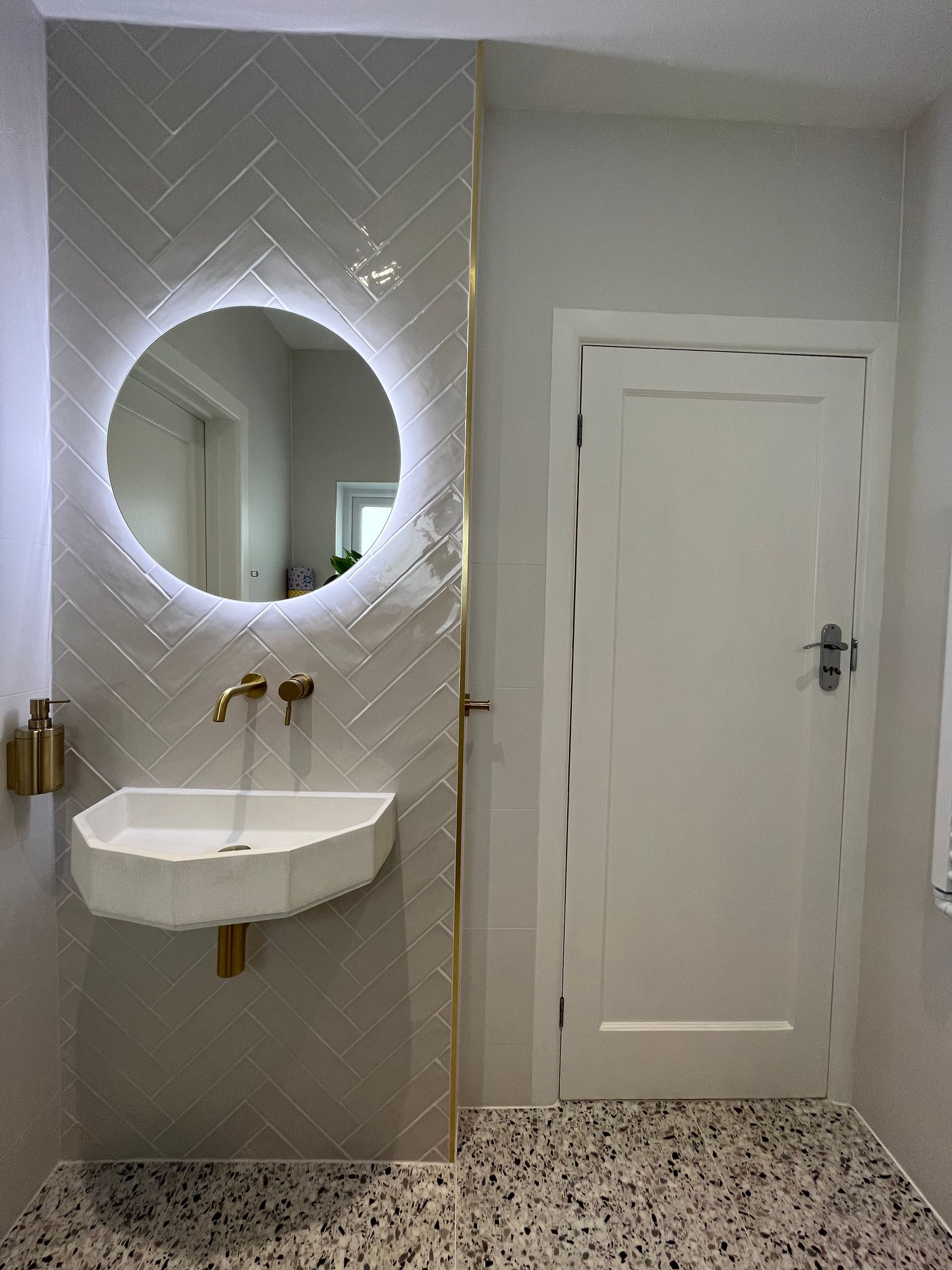 Farmhouse blanco on the walls with a lit up mirror and sink