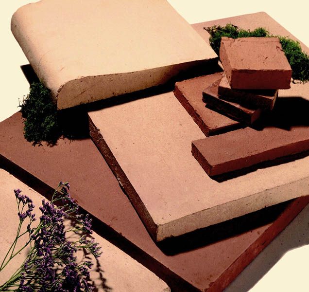 Natural terracotta outside in the sunlight next to some plants