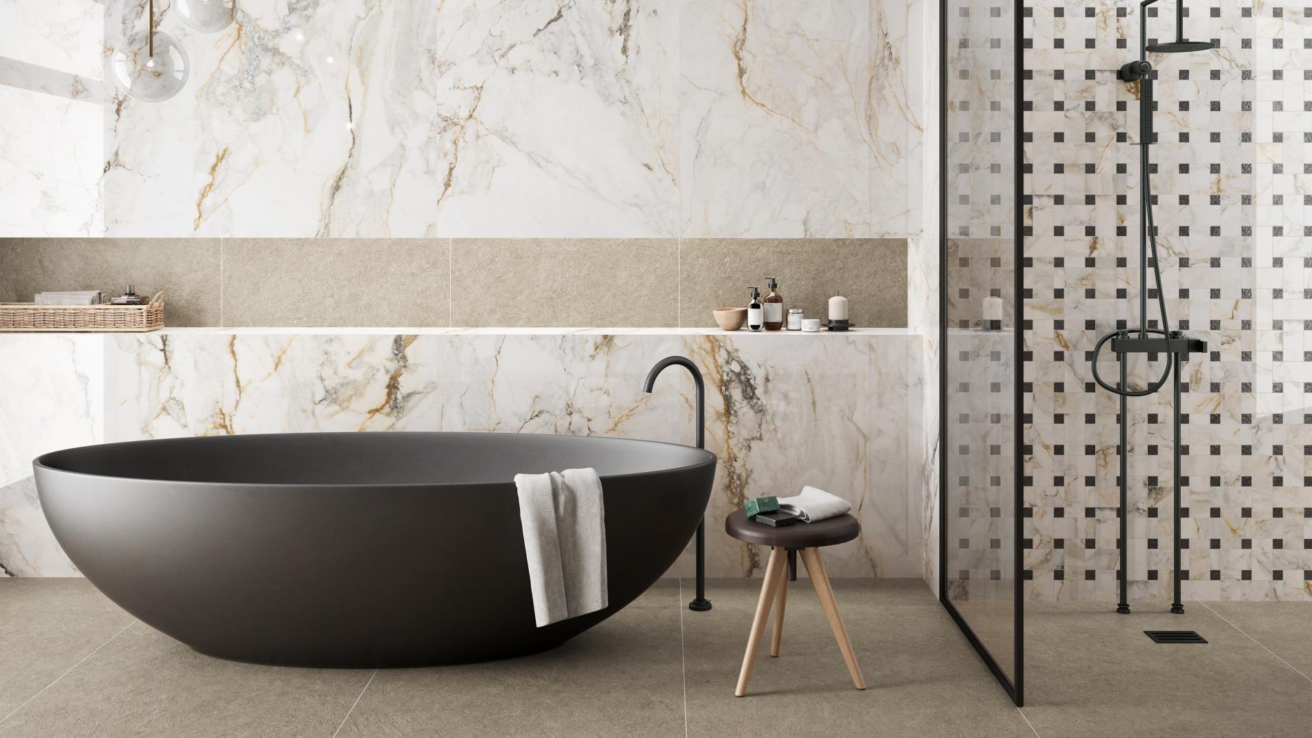 Black bath with marble wall tiles behind it and a shower on the right