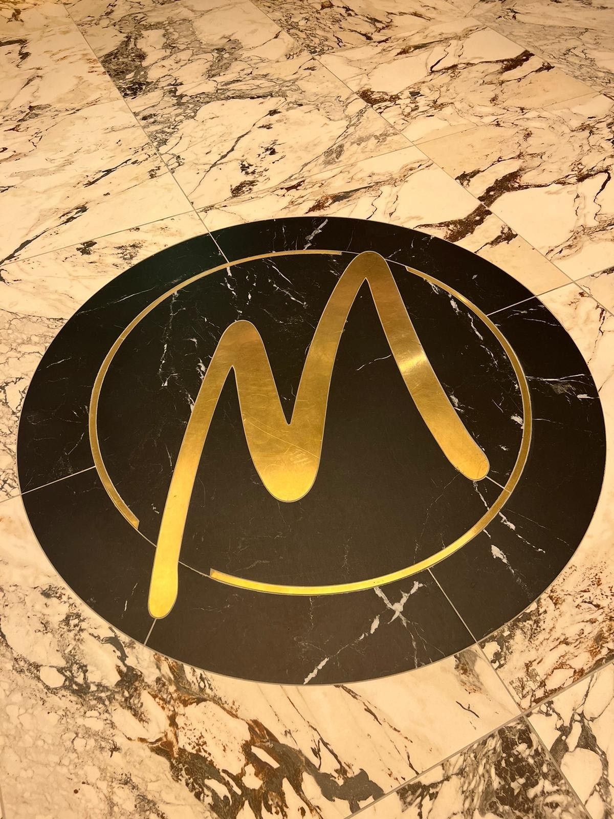 a golden m made from mosaic tiles