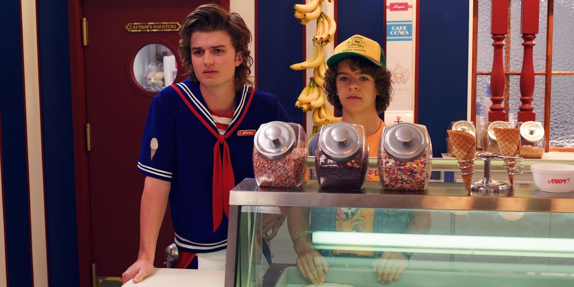 Steve and dustin at scoops ahoy stood behind the ice cream counter