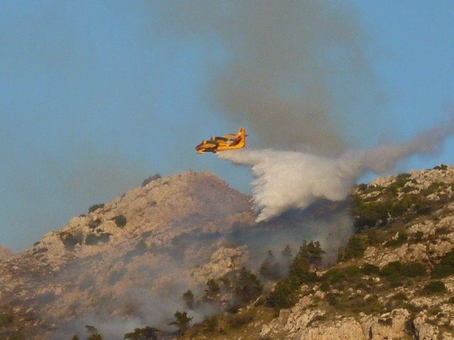 Fire plane dropping water on a fire on Hydra Island Greece.