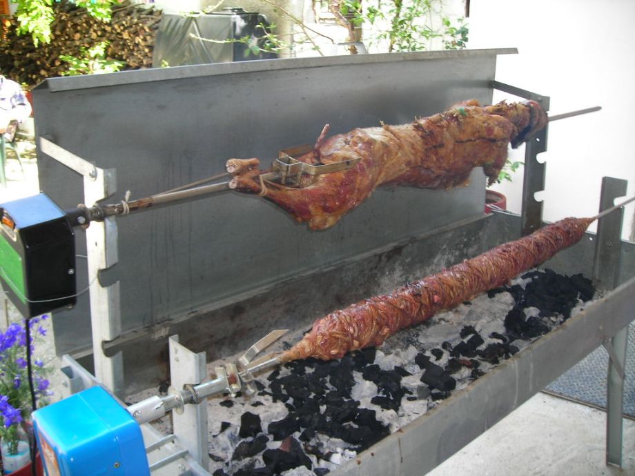 Traditional food for Greek Pascha (Easter) Sunday of lamb and kokoretsi roasted over charcoal BBQ's in Hydra Island, Greece. Easter Sunday Lamb and Kokoretsi on the spit on Hydra Island Greece.