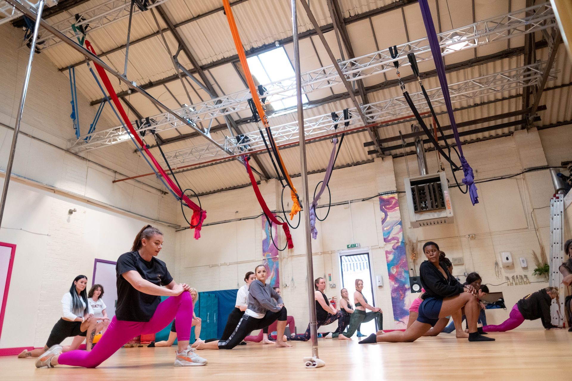 The group warm up for pole fitness, aerial circus and circus arts classes