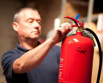 Service engineer inspecting a water fire extinguisher