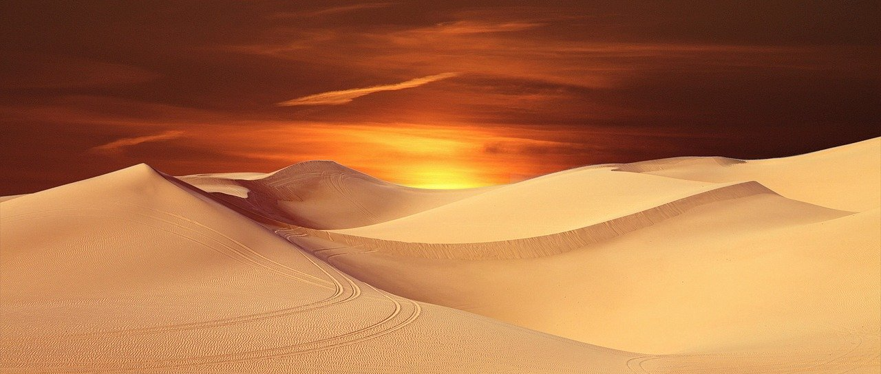 Dünen unter einem rötlichen Sonnenuntergang