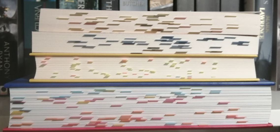 Vier Bücher mit dem Schnitt nach vorne, sodass man die Post-Its zwischen den Seiten sehen kann