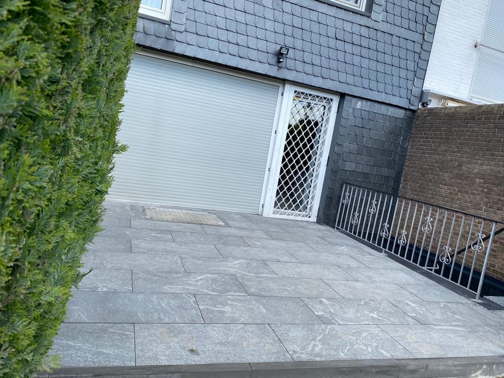 Nachher Terrassenbau Aubing-Freiham: robuste, drainage-starke Keramik-Terrasse in Neubau-Garten – BE Gartenbau München