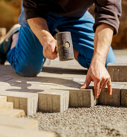 photo of man installing pavers
