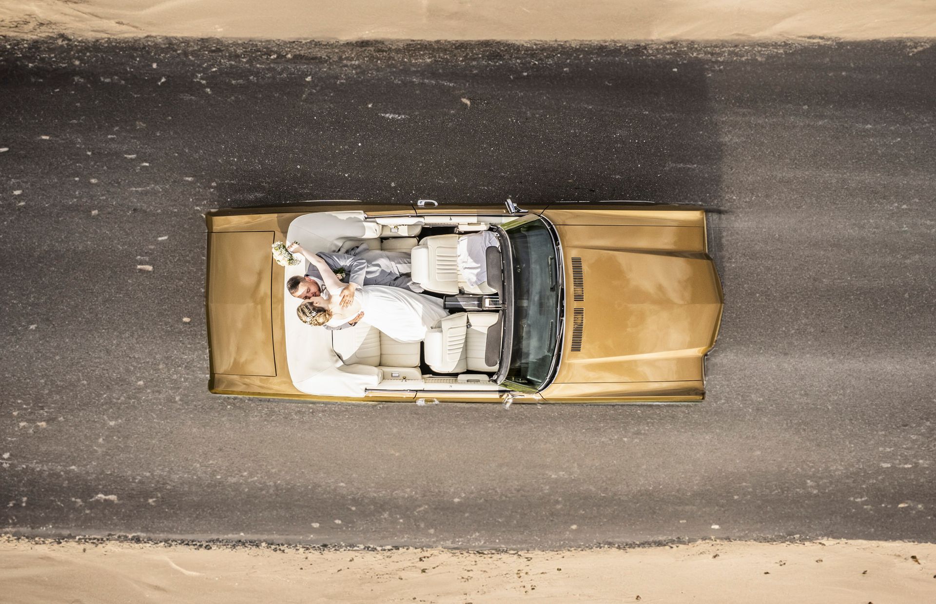 Hochzeitspaar knutscht im Muscle Car beim Hochzeitsshooting mit Drohne von Jan Grube in Glückstadt