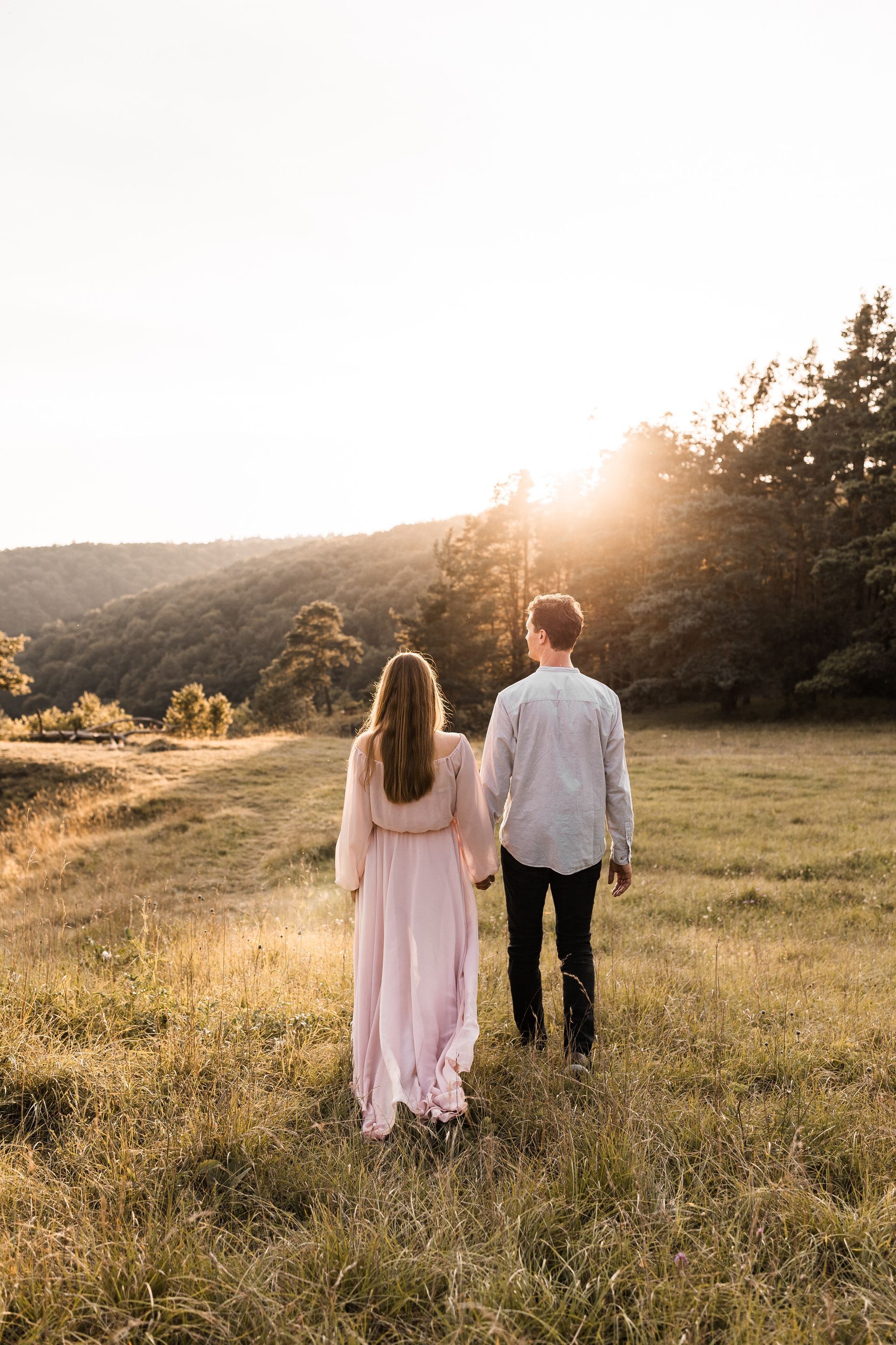 Auf diesem Bild sieht man eine Frau und ihren Mann beim Babybauchshooting