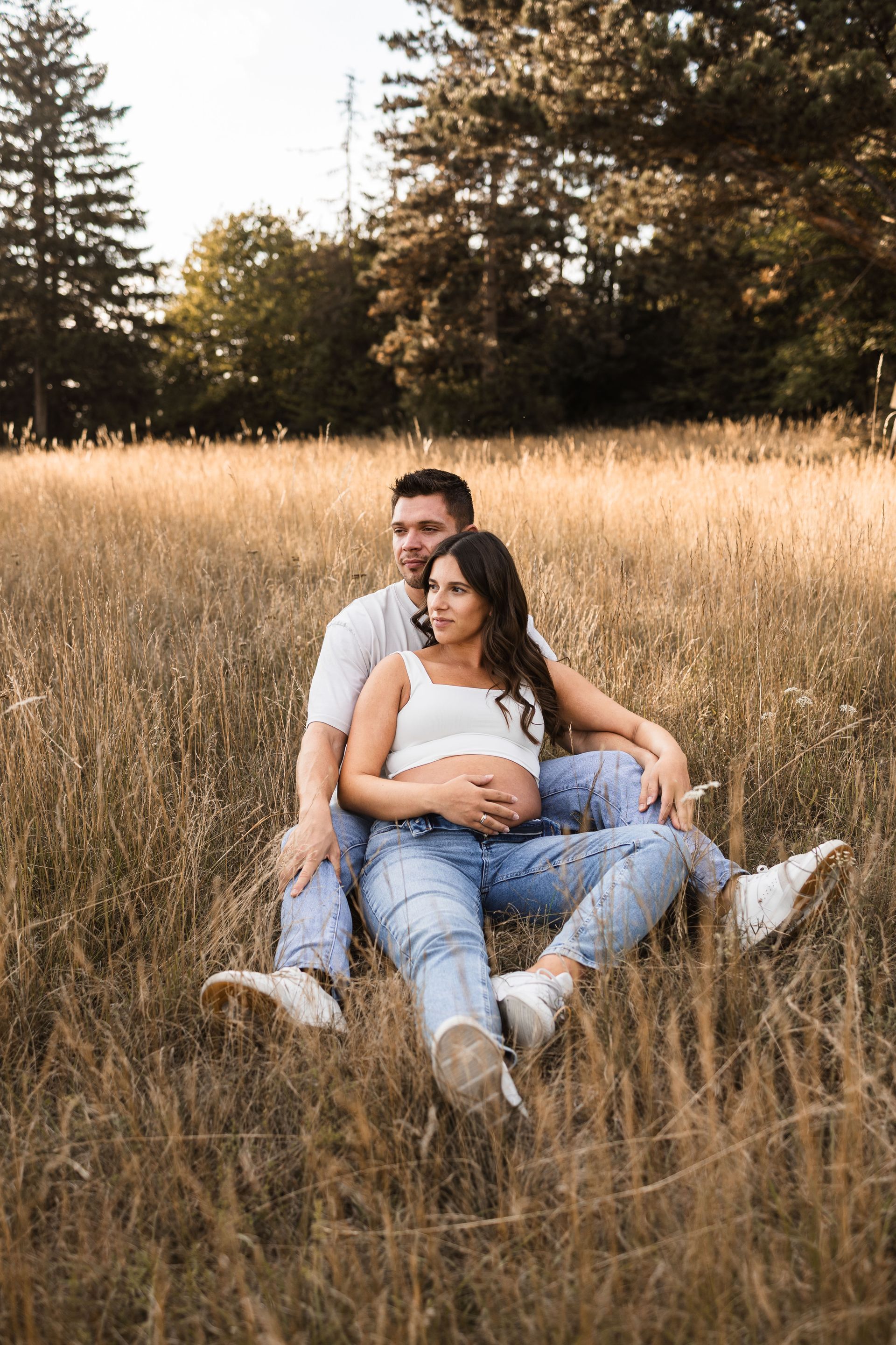 Auf diesem Bild sieht man eine Frau und ihren Mann beim Babybauchshooting