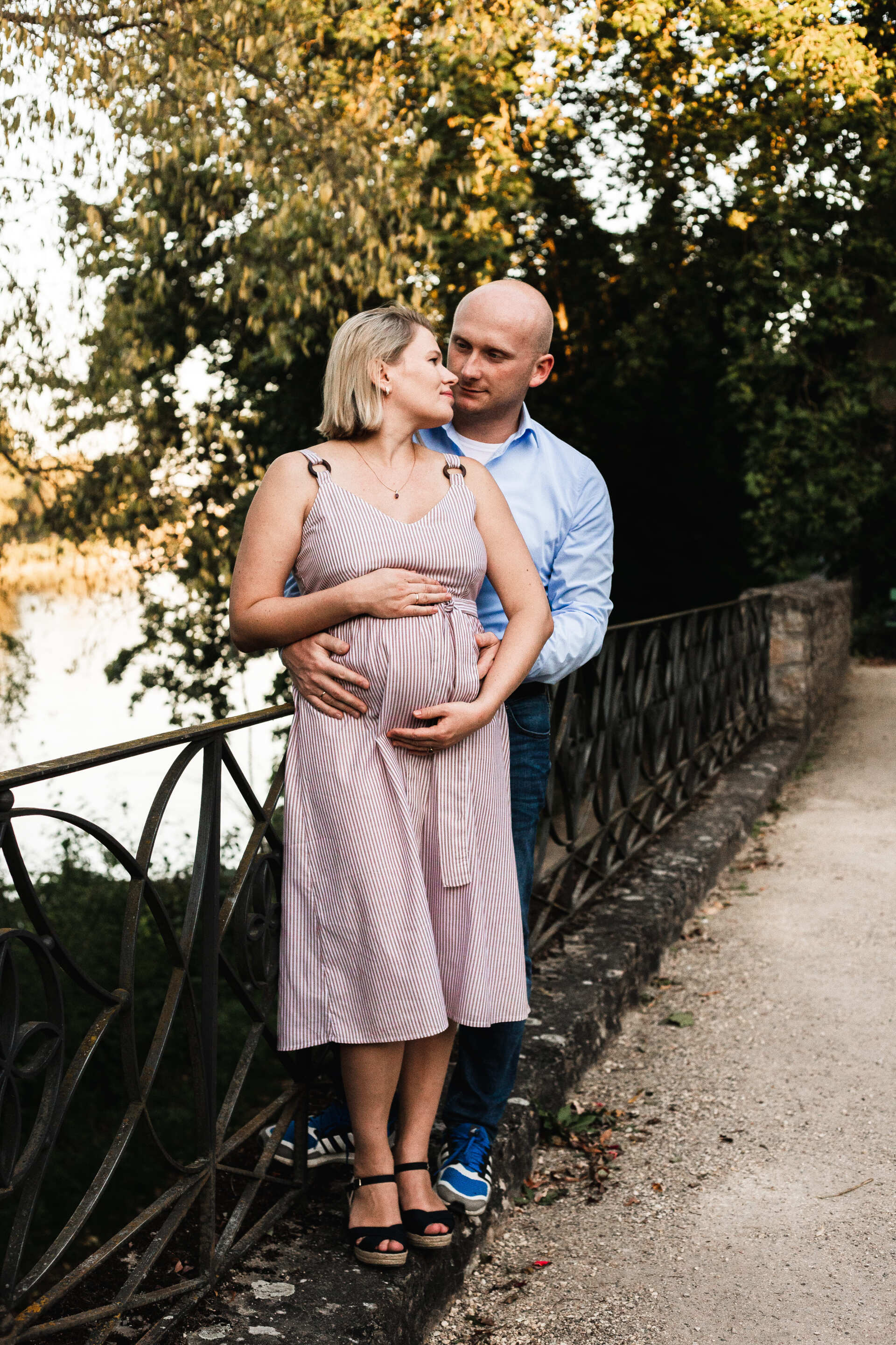Auf dem Bild sieht man einen Mann mit seiner Frau beim Babybauchshooting in Regensburg