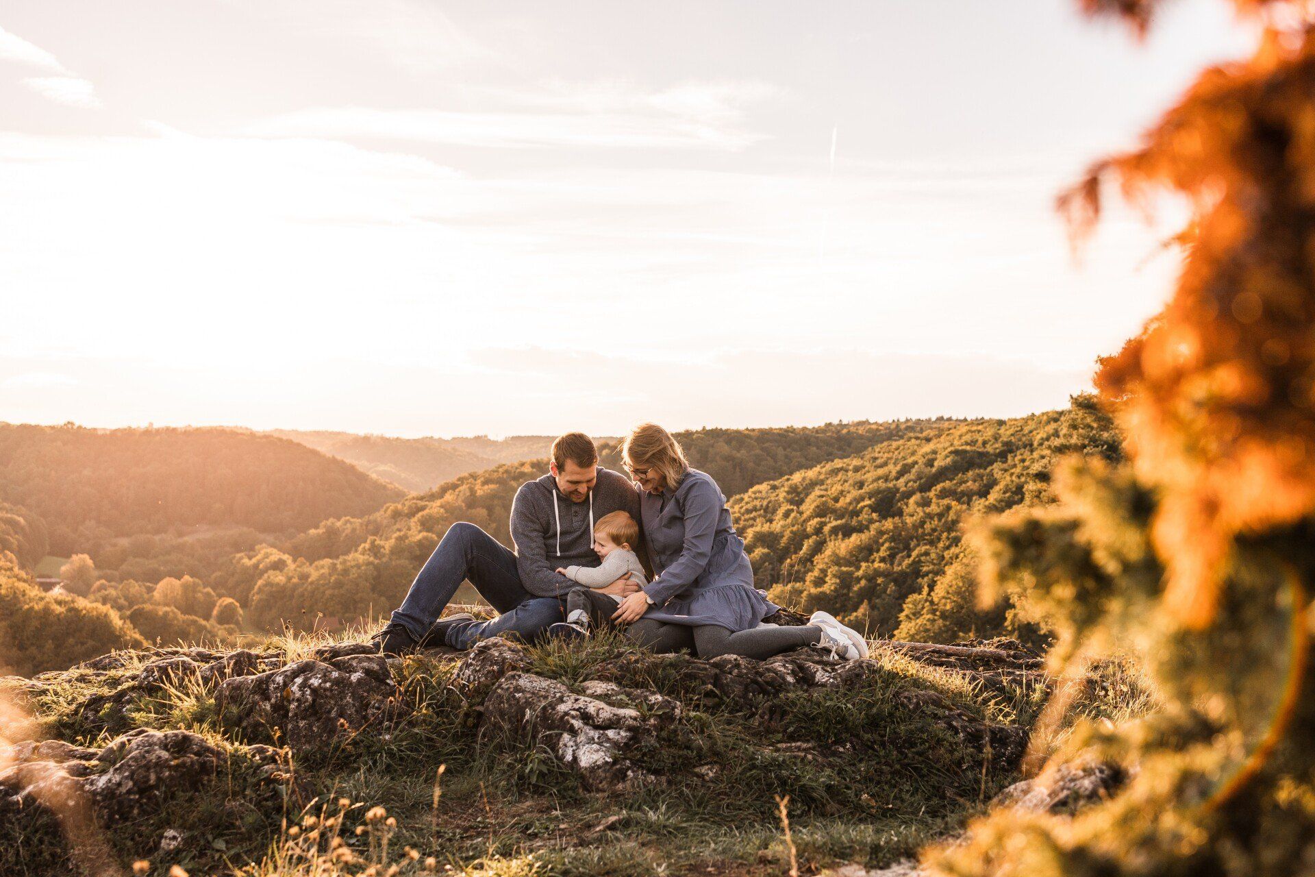 Dieses Bild zeigt eine junge Familie auf einem Steinfelsen