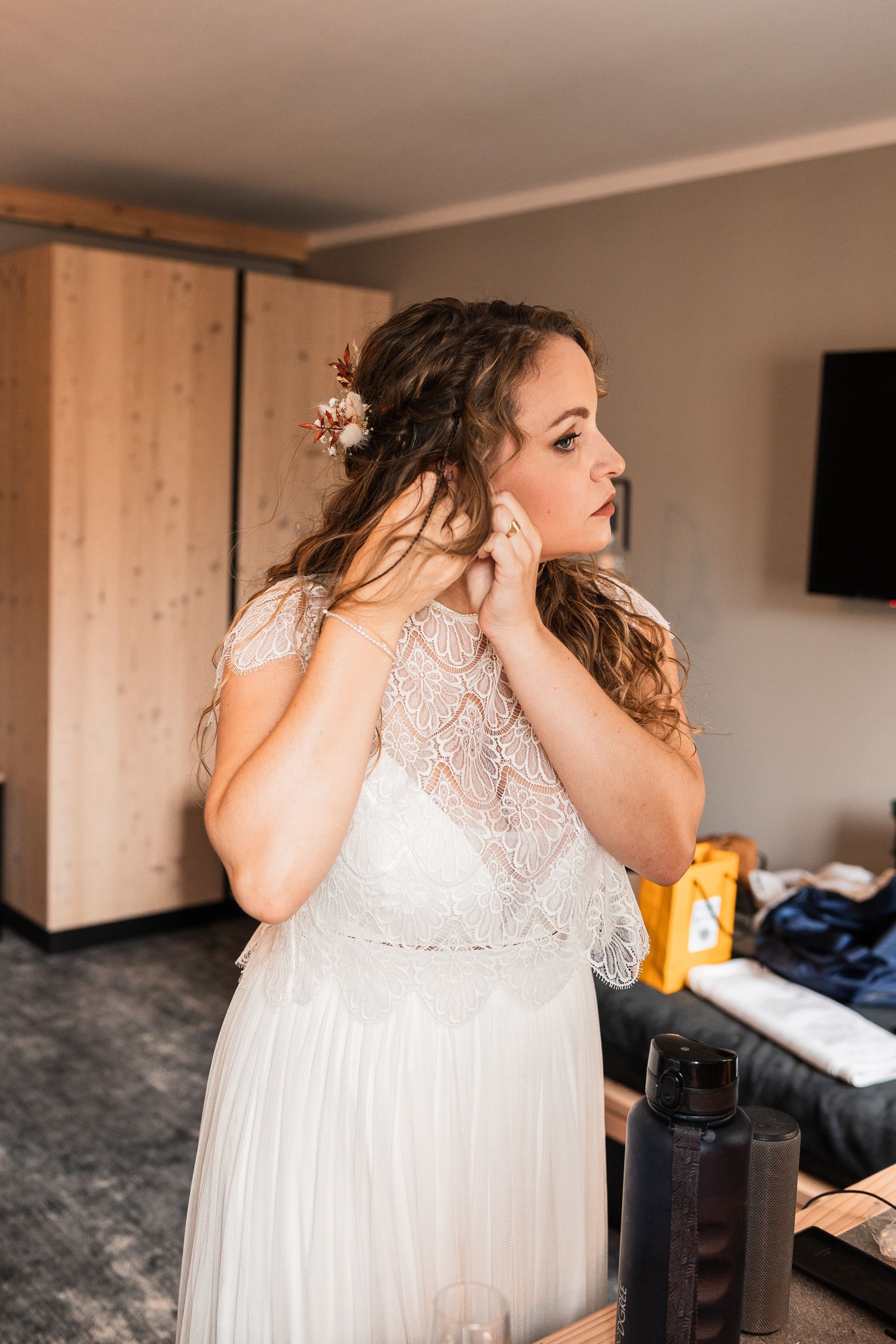 Braut legt sich ihren Schmuck an Auf diesem Foto legt sich die Braut ihren Schmuck an