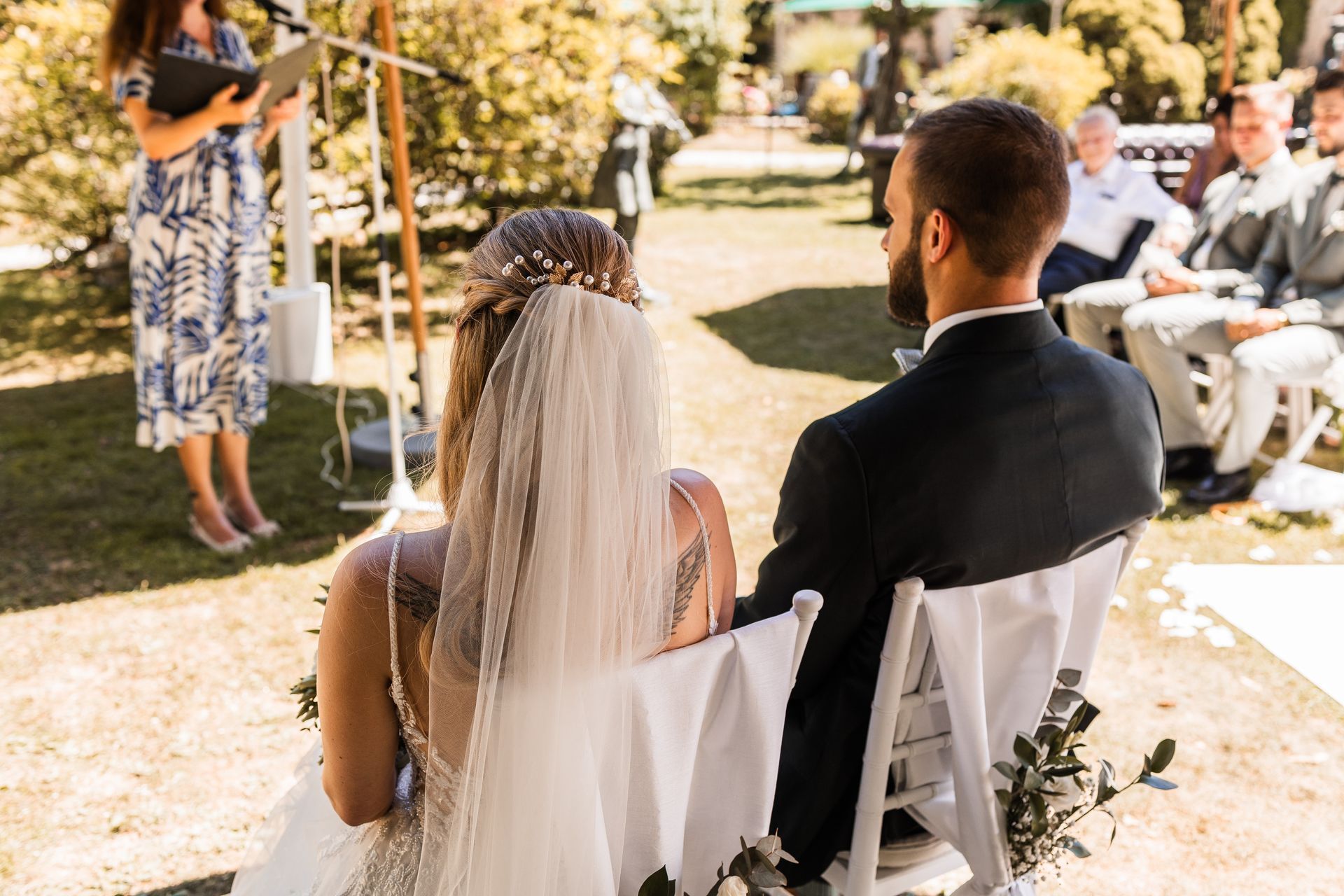 Auf diesem Foto sieht man das Brautpaar bei der Trauung sitzen