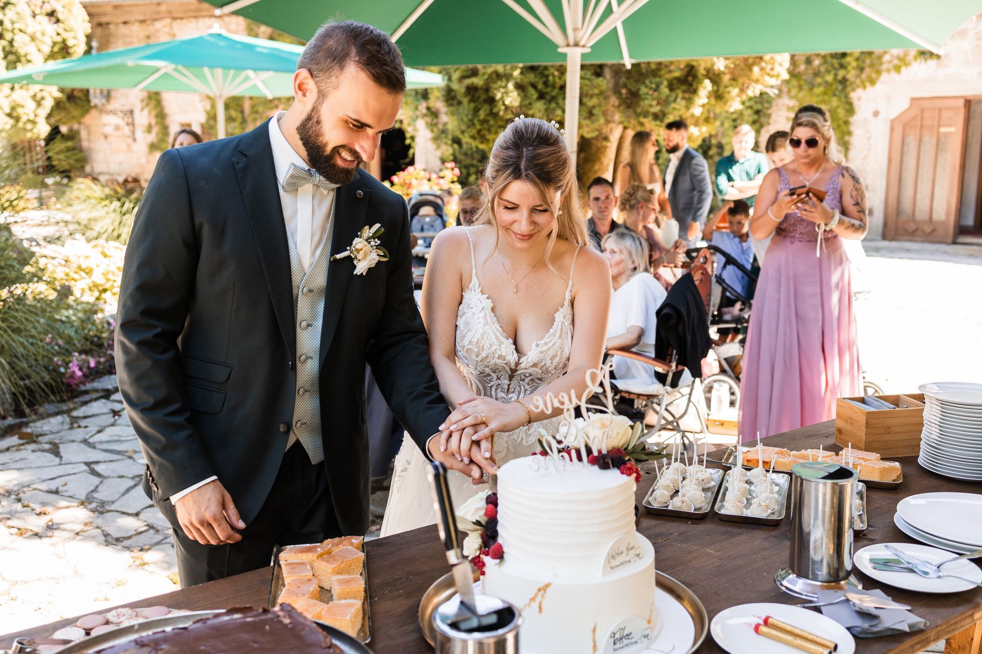 Brautpaar schneidet die Hochzeitstorte an Auf diesem Foto schneidet das Brautpaar die Hochzeitstorte an