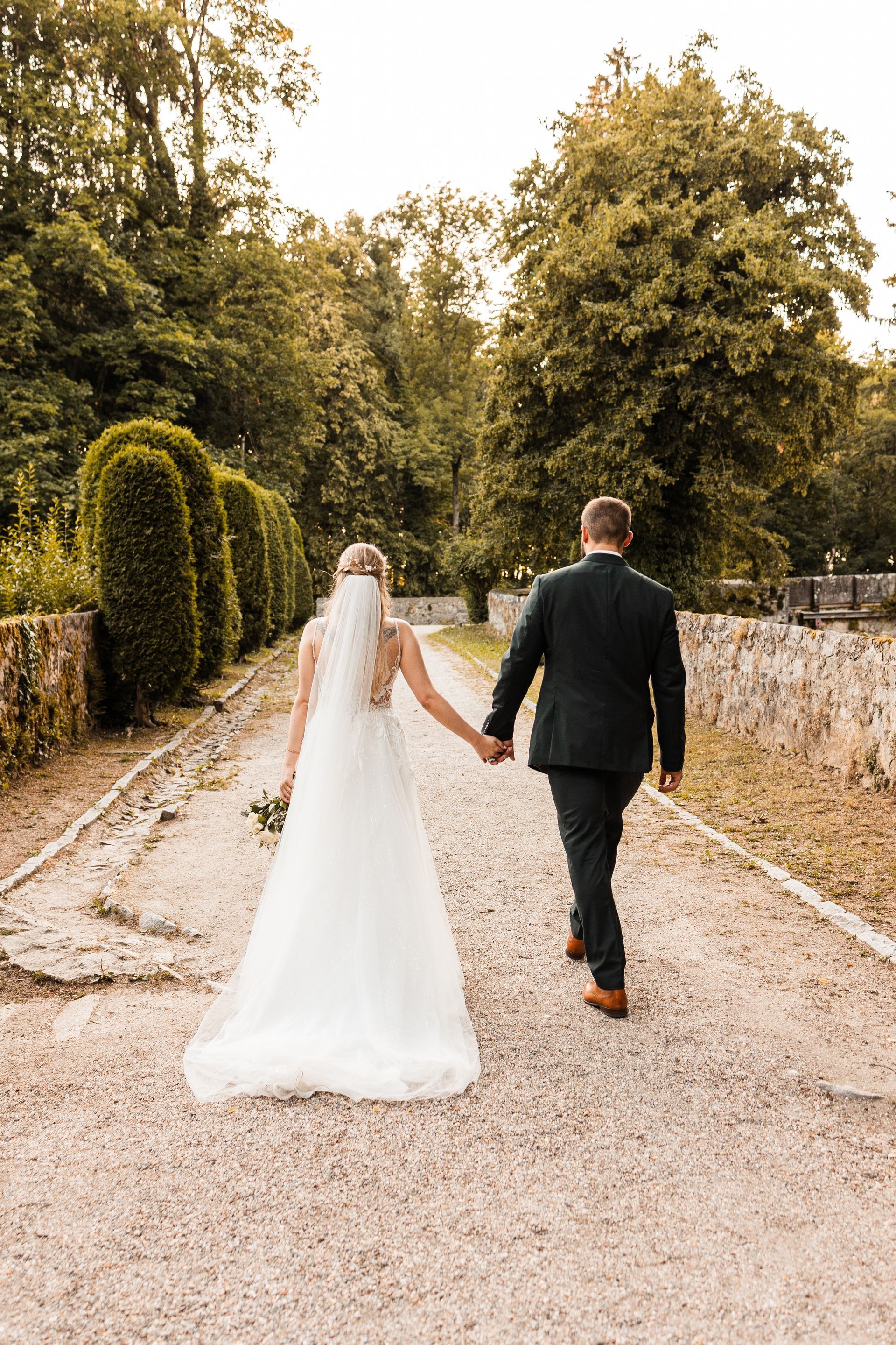 Brautpaar Hand in Hand Auf diesem Foto geht ein Brautpaar Hand in Hand