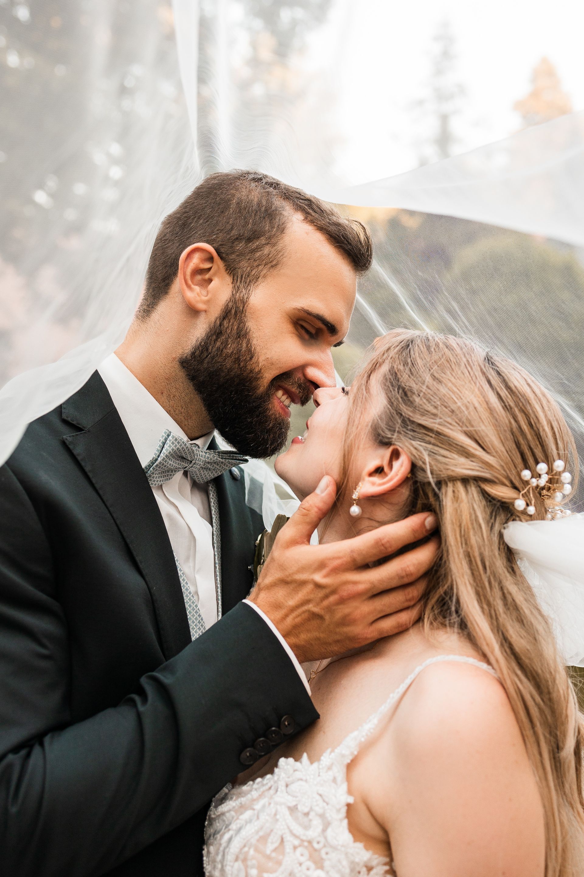 Auf diesem Bild sieht man ein Brautpaar unter einem Schleier