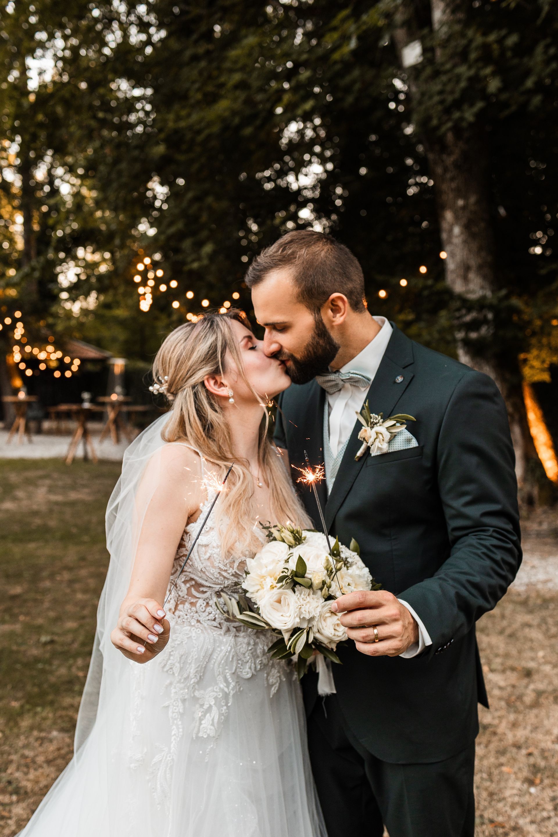Brautpaar küsst sich und hält Wunderkerzen in der Hand Auf diesem Foto küsst sich ein Brautpaar und hält Wunderkerzen in der Hand
