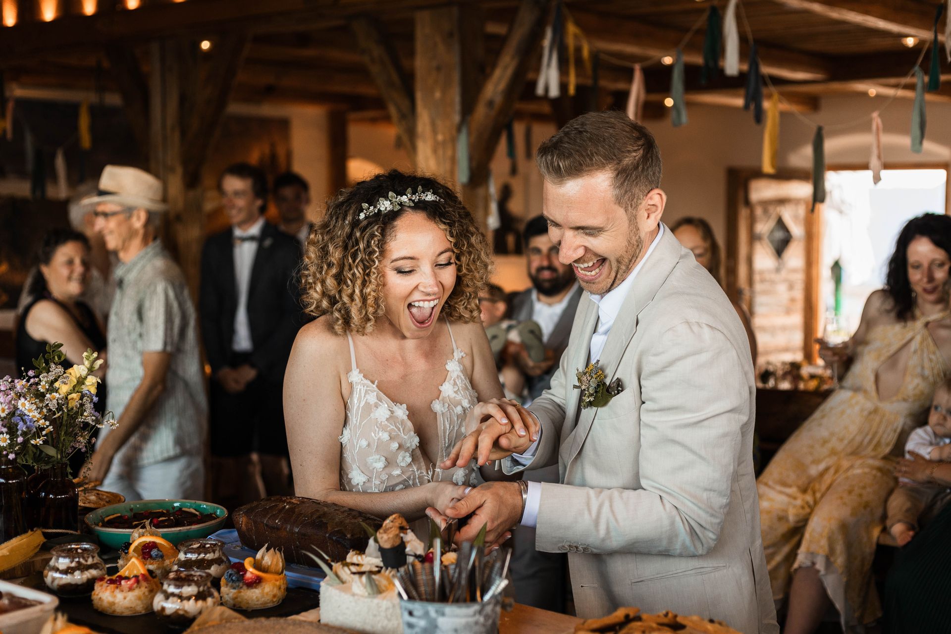 Auf diesem Foto sieht man ein Brautpaar, das die Hochzeitstorte anschneidet