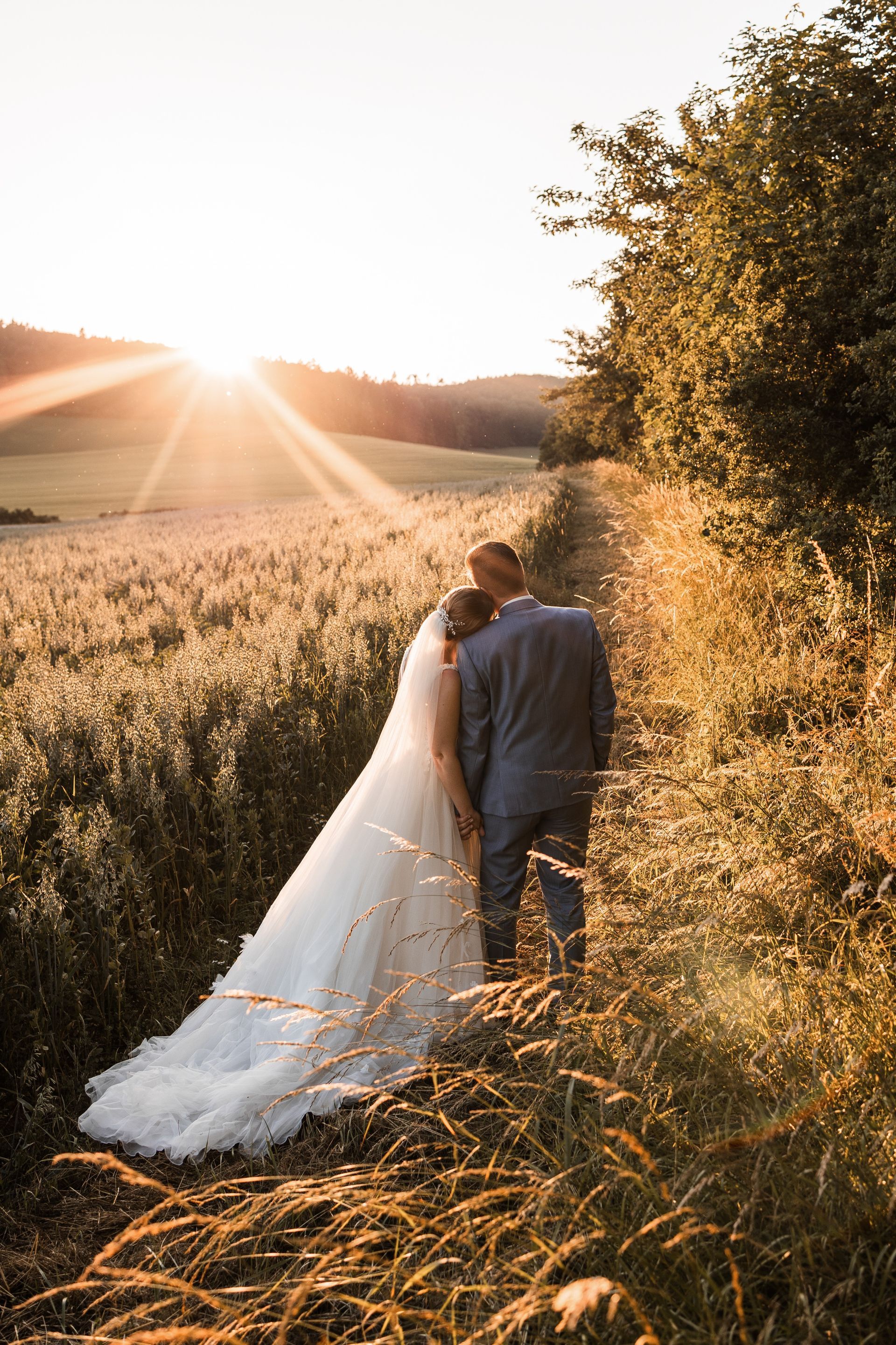 Das Foto zeigt ein Brautpaar im Sonnenuntergang