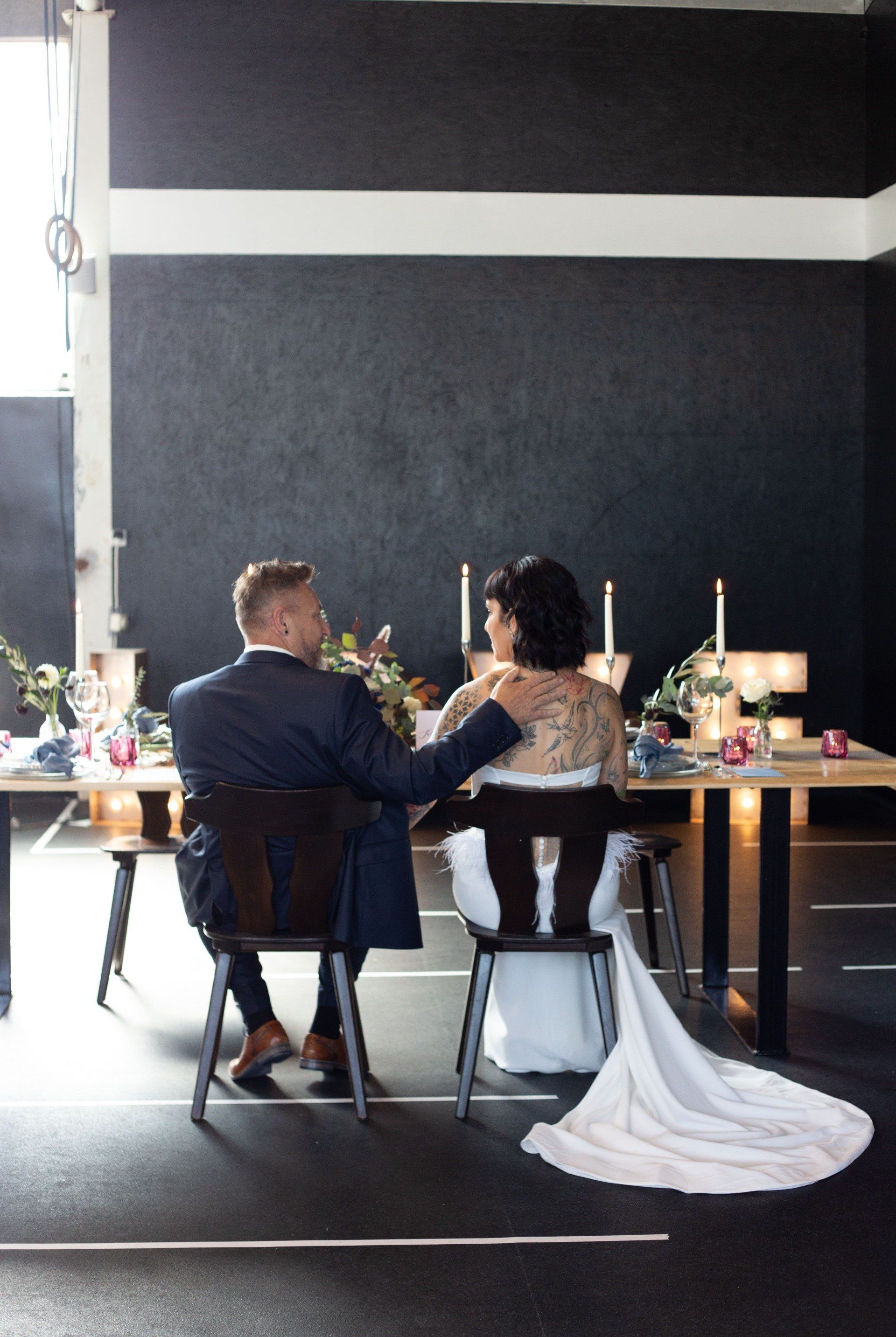 Dieses Bild zeigt ein Brautpaar an einem Tisch sitzend