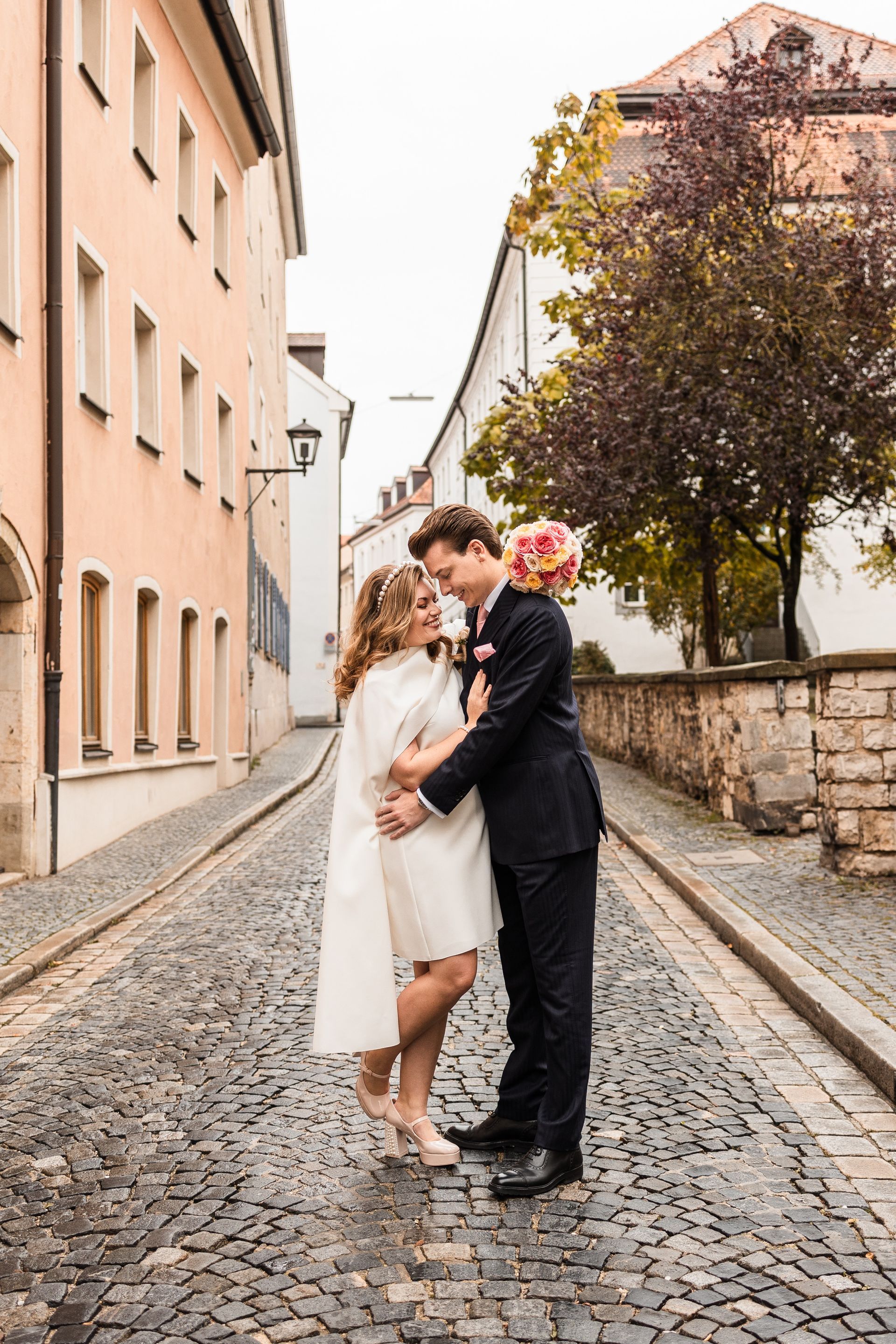 Auf diesem Foto spaziert ein Brautpaar durch die Stadt