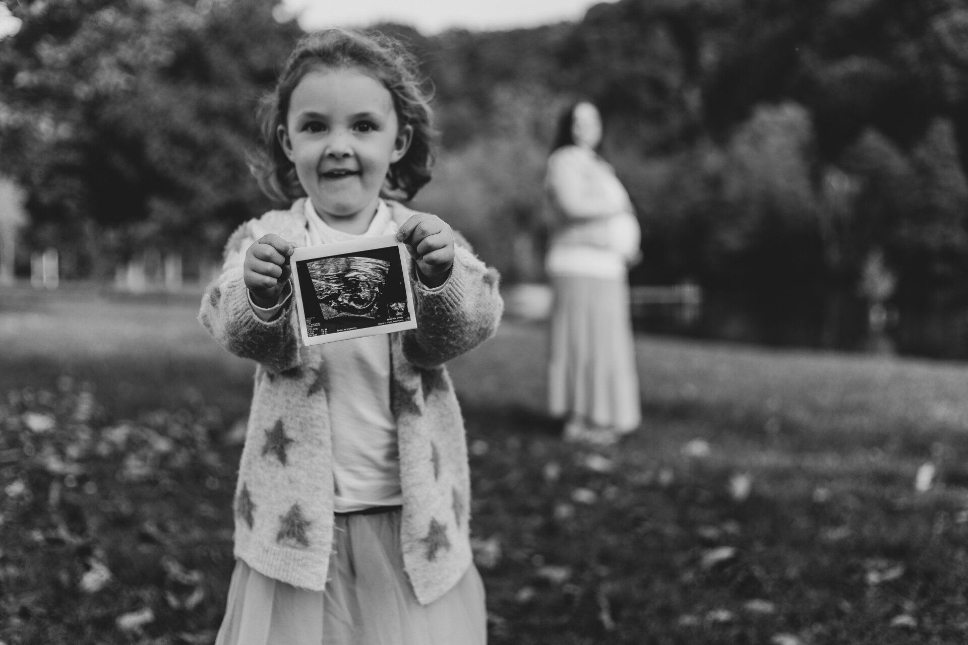 Kind hält Ultraschallbild Auf diesem Bild hält die Tochter das Ultraschallbild der schwangeren Mutter