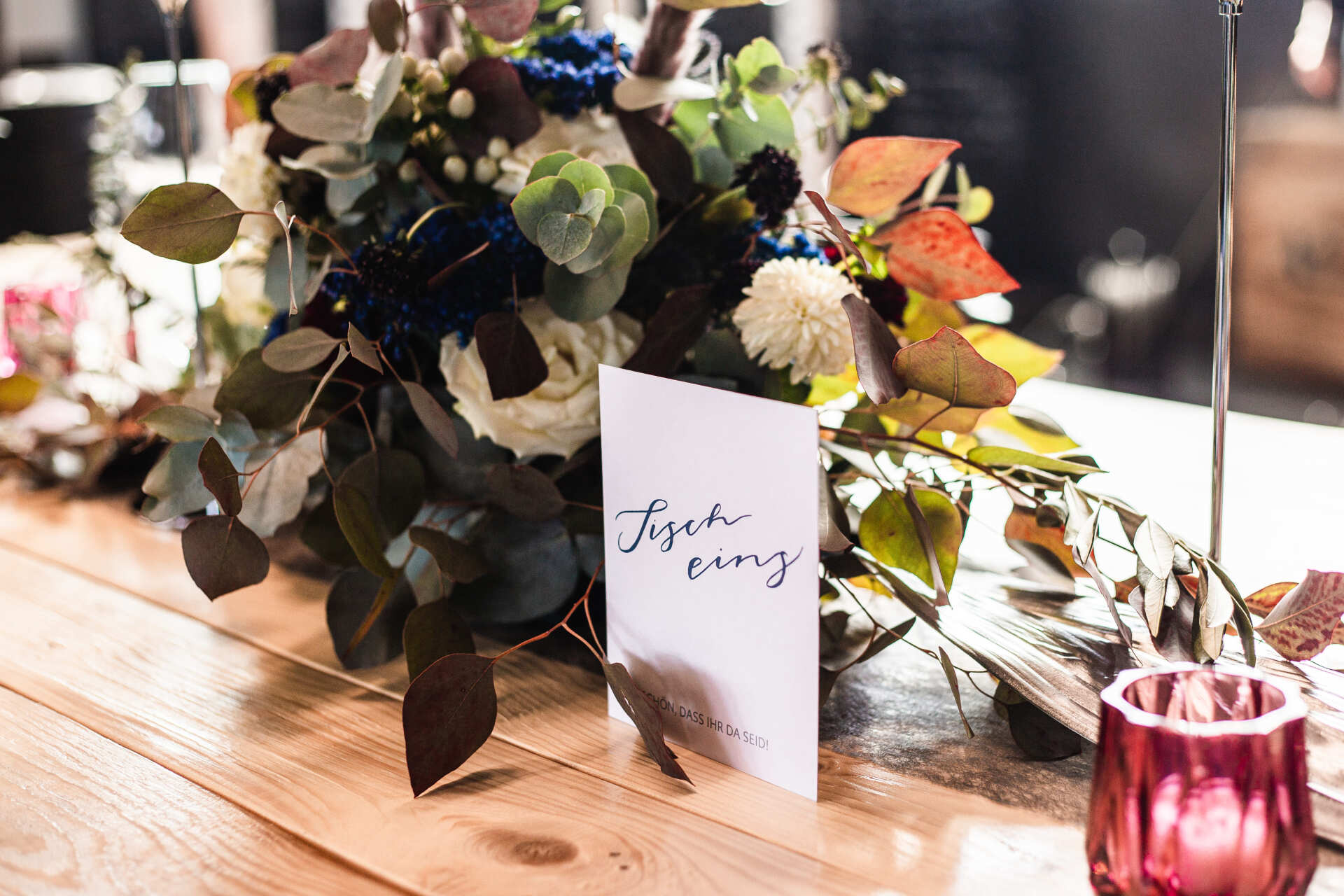 Tischkarte zusammen mit Tischdekoration und Blumen Auf dem Foto sieht man Tischdekoration und eine Tischkarte